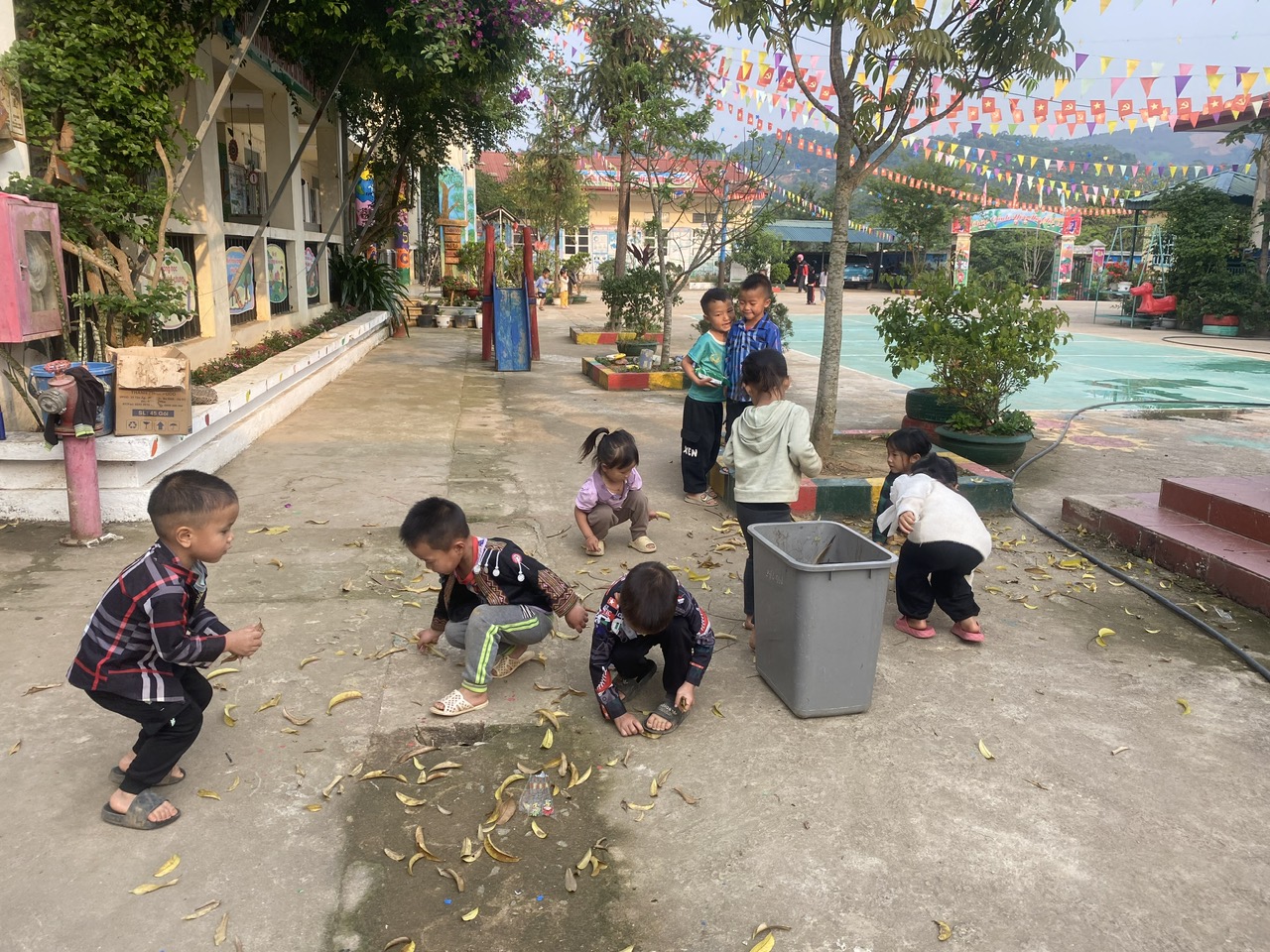 ảnh trẻ nhặt lá cây